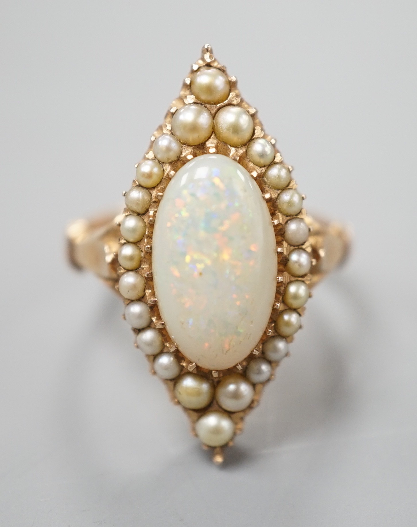 A yellow meat, white opal and seed pearl set marquise shaped cluster ring, size J/K, gross weight 5.6 grams.